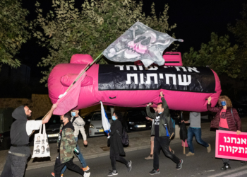 דניאל פלנקר מניף דגל פיראטים בצעדה | צילום: מולי גולדברג