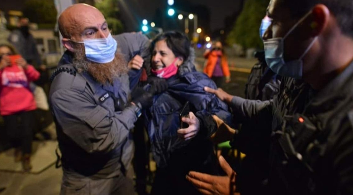 עבד נערני עוצר את אחת המפגינות | צילום: מתן גולן