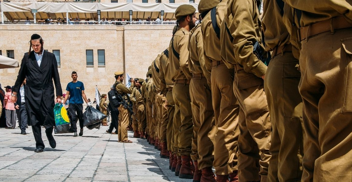 צעיר חרדי צועד ליד חיילים | צילום: שאטרסטוק