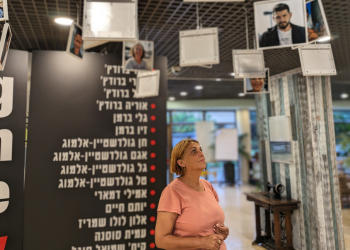 חברת הכנסת לשעבר נירה שפק עם תמונות החטופים מכפר עזה, בכפר הנופש שפיים | צילום: נתן רושנסקי