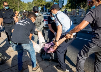 סייר ביטחון של עיריית ירושלים מסייע למשטרה לפנות מאהל מחאה נגד הממשלה (צילום: יונתן סינדל, פלאש 90)
